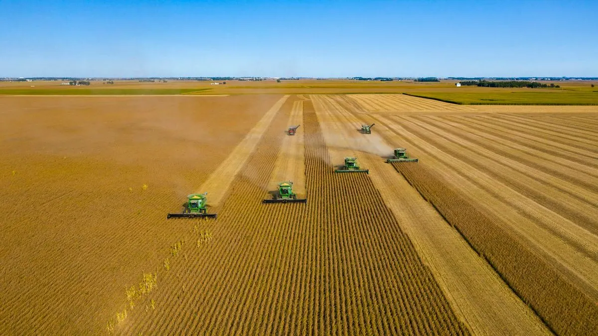 Agricultural machinery working across open field rows in a rural landscape, representing land-based equipment rental and farm operations support.